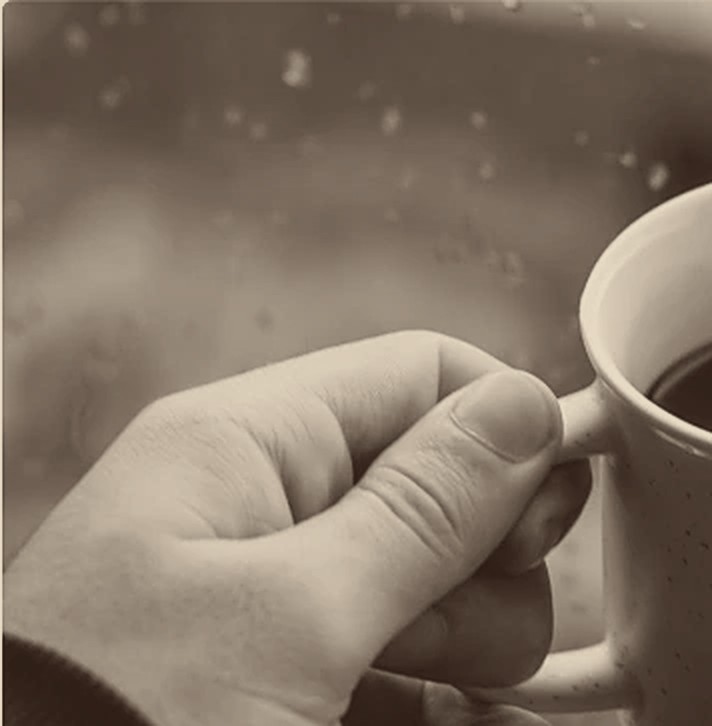 Taza de café junto a la ventana con lluvia